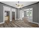 Open living room featuring hardwood floors, ceiling fan, and access to the bathroom and the adjacent room at 761 N Holmes Ave, Indianapolis, IN 46222