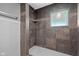 Close-up of shower with tan tiles, a window, and tiled shower head with small shelf at 761 N Holmes Ave, Indianapolis, IN 46222