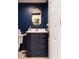 Navy-blue bathroom featuring a vanity with gold handles and a white door at 7612 Farm View E Cir, Indianapolis, IN 46256