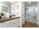 This inviting bathroom features a single sink vanity, granite countertop, white cabinets, and a glass door shower at 7612 Farm View E Cir, Indianapolis, IN 46256