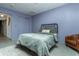 Relaxing bedroom showcasing a metal bed frame, light green bedding, and carpet flooring at 7612 Farm View E Cir, Indianapolis, IN 46256