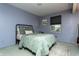 Cozy bedroom featuring soft green bedding, black frame bed, and a stylish area rug at 7612 Farm View E Cir, Indianapolis, IN 46256