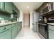 Well-equipped kitchen with stainless steel appliances, light-green cabinetry, and tile flooring at 7612 Farm View E Cir, Indianapolis, IN 46256