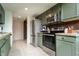 Well-equipped kitchen featuring stainless steel appliances and light-green cabinetry at 7612 Farm View E Cir, Indianapolis, IN 46256