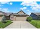 Charming single-story home with a two-car garage, complemented by lush greenery and a well-maintained lawn at 785 Cottage Ln, Greenwood, IN 46143
