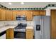 A cozy kitchen features tile floors, wooden cabinets, and modern stainless steel appliances at 785 Cottage Ln, Greenwood, IN 46143