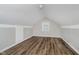Finished attic featuring wood-look flooring, a small window, and neutral paint at 8912 Robey Dr, Indianapolis, IN 46234