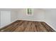 Finished attic featuring wood-look flooring, a small window, and neutral paint at 8912 Robey Dr, Indianapolis, IN 46234