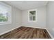Cozy bedroom with wood-look floors and natural light from two large windows at 8912 Robey Dr, Indianapolis, IN 46234