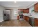 Well-lit kitchen with stainless steel appliances, wood cabinets, and modern fixtures at 8912 Robey Dr, Indianapolis, IN 46234
