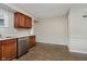 Open kitchen area with stainless steel dishwasher, wood cabinets, and wood-look flooring at 8912 Robey Dr, Indianapolis, IN 46234