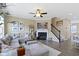 Comfortable living room with fireplace, ceiling fan, plush sectional sofa, and staircase at 9476 Oakley Dr, Indianapolis, IN 46260