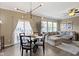 Open concept living room featuring a glass dining table, modern chandelier, neutral walls, and hardwood floors at 9476 Oakley Dr, Indianapolis, IN 46260