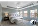 Serene main bedroom with a tray ceiling, ceiling fan, and plenty of natural light from the windows at 9476 Oakley Dr, Indianapolis, IN 46260