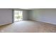 Spacious living room featuring neutral carpet and sliding door to the outdoor deck at 951 W Mckay Rd, Shelbyville, IN 46176