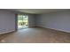 Spacious living room with sliding glass doors leading to a private outdoor area, neutral carpet at 951 W Mckay Rd, Shelbyville, IN 46176