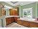 Light-filled bathroom showcasing a soaking tub with wood cabinetry and large window at 9690 Irishmans Run Ln, Zionsville, IN 46077