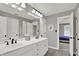 Bright bathroom featuring a double sink vanity, large mirror, and plenty of storage space at 9690 Irishmans Run Ln, Zionsville, IN 46077
