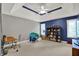 Spacious bedroom with blue accent wall, bookshelves, and tray ceiling at 9690 Irishmans Run Ln, Zionsville, IN 46077