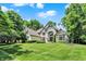 Beautiful stone-clad home with a manicured lawn and mature trees, offering classic elegance and curb appeal at 9690 Irishmans Run Ln, Zionsville, IN 46077
