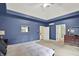 This primary bedroom boasts a tray ceiling, large windows and neutral carpet flooring at 9690 Irishmans Run Ln, Zionsville, IN 46077
