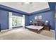 This primary bedroom boasts a tray ceiling, large windows and neutral carpet flooring at 9690 Irishmans Run Ln, Zionsville, IN 46077