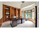Office featuring custom built-in shelves, a large wooden desk, and a bay window at 9690 Irishmans Run Ln, Zionsville, IN 46077