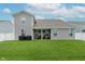 Spacious backyard with a well-maintained lawn, covered patio, and white fence at 9806 Olympic Blvd, Pendleton, IN 46064