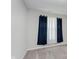 Minimalist bedroom corner with dark blue curtains, a window, and neutral walls at 9806 Olympic Blvd, Pendleton, IN 46064