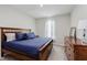 Cozy bedroom with a wooden bed frame, blue comforter, and a matching dresser at 9806 Olympic Blvd, Pendleton, IN 46064