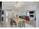 Open-concept dining area with a modern chandelier flows into a cozy living space with a stone fireplace at 10107 Landis Blvd, Fishers, IN 46040