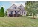 Attractive two-story home with manicured lawn, garden beds, brick accents, and neutral siding at 10107 Landis Blvd, Fishers, IN 46040