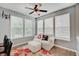 Cozy sunroom bathed in natural light, complete with a ceiling fan, plush seating, and wood-look flooring at 10107 Landis Blvd, Fishers, IN 46040