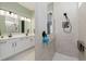 Modern bathroom featuring a tiled shower with built-in niche, a double sink vanity with white cabinets, and updated fixtures at 10725 Crum Ct, Fishers, IN 46037