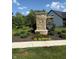 Stone community sign featuring manicured landscaping and a view of the new home at 10725 Crum Ct, Fishers, IN 46037