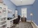 Bright office features blue walls, functional desk with modern decor, and a ceiling fan at 10725 Crum Ct, Fishers, IN 46037