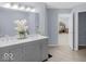 Bright bathroom featuring a double sink vanity with gray cabinets and a view into the bedroom at 1119 Albemarle Cir, Noblesville, IN 46062