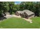 Aerial view shows a well-maintained brick house, detached garage, lush lawn, and surrounding trees at 1125 Observatory Rd, Martinsville, IN 46151