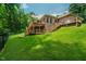 Large backyard featuring multi-level deck, stairs, lush greenery, and partial fencing for outdoor relaxation at 1125 Observatory Rd, Martinsville, IN 46151