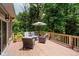 Relaxing outdoor deck with cushioned seating, umbrella shade, and surrounding views of lush green trees at 1125 Observatory Rd, Martinsville, IN 46151