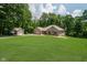 A well-maintained lawn surrounds a beautiful brick house with a detached garage on a sunny day at 1125 Observatory Rd, Martinsville, IN 46151