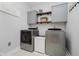 Well-lit laundry room with gray cabinets, wood shelves and front loading machines at 1125 Observatory Rd, Martinsville, IN 46151