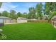 Large backyard with lush green lawn, surrounded by mature trees and a wooden fence for privacy at 1149 E 56Th St, Indianapolis, IN 46220