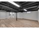 Finished basement area with wood-look floors, painted beams, and white walls at 1149 E 56Th St, Indianapolis, IN 46220