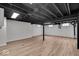 Finished basement area with wood-look floors, painted beams, and white walls at 1149 E 56Th St, Indianapolis, IN 46220