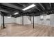 Finished basement area with wood-look floors, painted beams, and white walls at 1149 E 56Th St, Indianapolis, IN 46220
