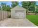 A single-car detached garage with a gravel driveway and a white door, surrounded by a green lawn at 1149 E 56Th St, Indianapolis, IN 46220