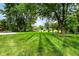 Expansive lawn area with mature trees, landscaping, and an outbuilding, perfect for outdoor enjoyment at 12020 Colbarn Dr, Fishers, IN 46038