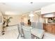 A dining table with seating for four sits adjacent to a kitchen area and a brightly lit living room at 12020 Colbarn Dr, Fishers, IN 46038