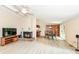 Well-lit living room with a fireplace, wood floors, and access to the dining area at 12020 Colbarn Dr, Fishers, IN 46038